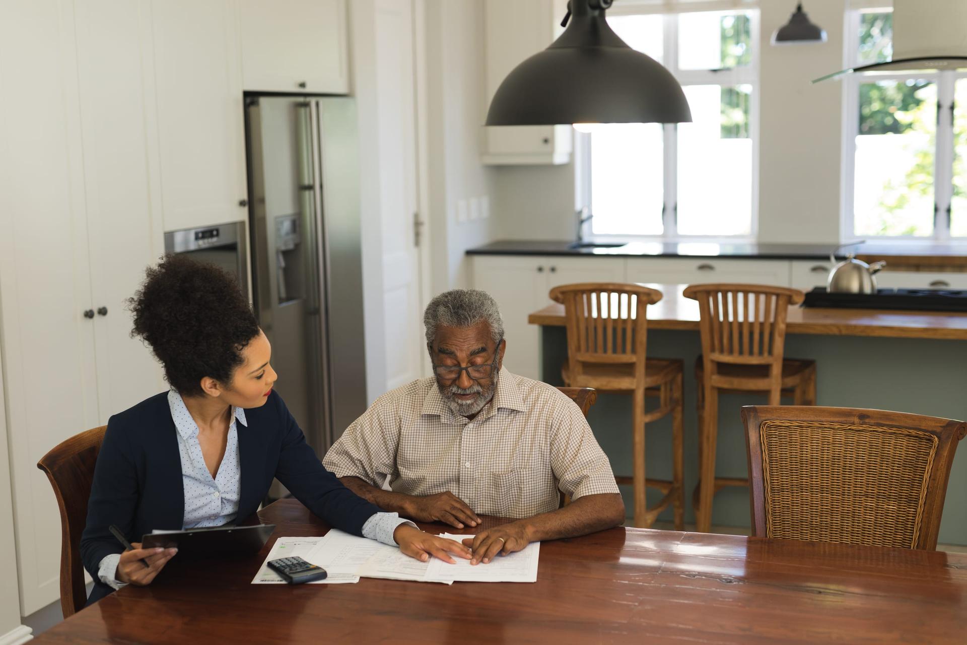 Two people going over contract documents at a table at home