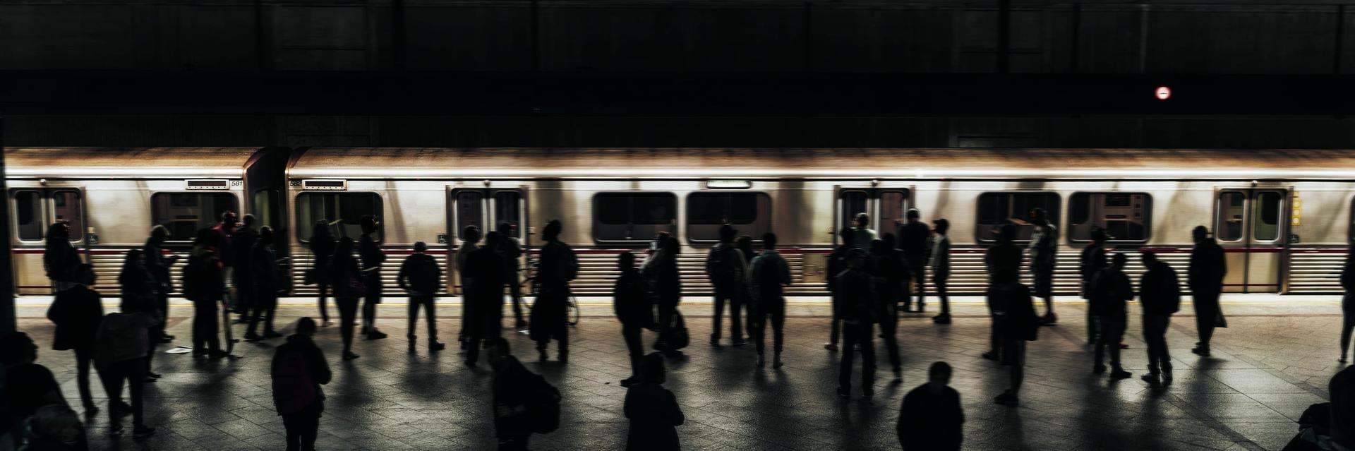 Commuters waiting on a subway platform as a train arrives