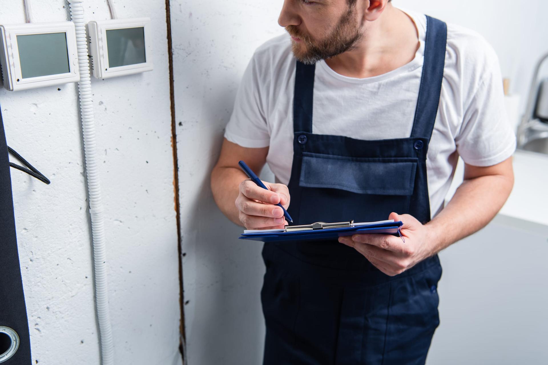 An inspector with a clipboard checking an electrical panel